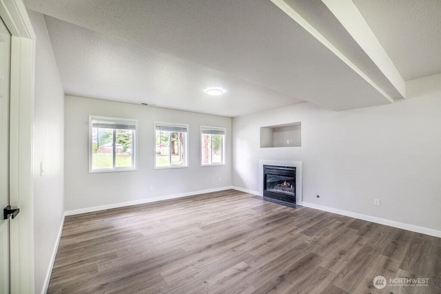 8302 319th St NW, Stanwood, WA 98292 - unfurnished living room with wood finished floors, a fireplace with flush hearth, and baseboards
