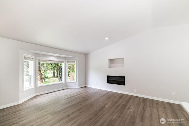 8302 319th St NW, Stanwood, WA 98292 - unfurnished living room with vaulted ceiling, wood finished floors, baseboards, and a glass covered fireplace