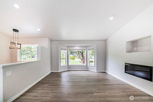 8302 319th St NW, Stanwood, WA 98292 - unfurnished living room featuring wood finished floors, a glass covered fireplace, recessed lighting, a chandelier, and baseboards