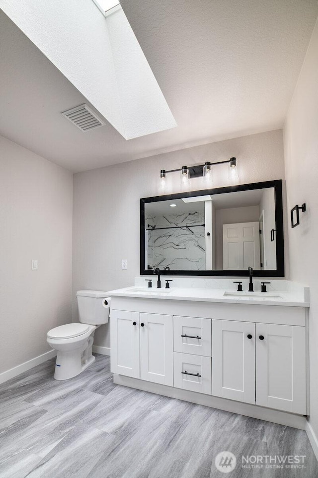 8302 319th St NW, Stanwood, WA 98292 - full bathroom featuring wood finished floors, baseboards, a marble finish shower, and double vanity