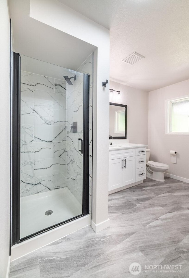 8302 319th St NW, Stanwood, WA 98292 - bathroom featuring a marble finish shower, baseboards, toilet, vanity, and wood finished floors