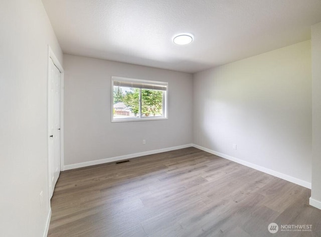 8302 319th St NW, Stanwood, WA 98292 - unfurnished bedroom with wood finished floors, baseboards, and a closet