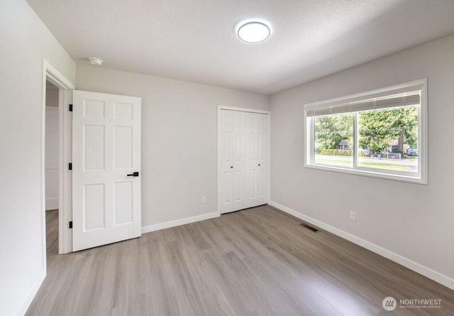 8302 319th St NW, Stanwood, WA 98292 - unfurnished bedroom featuring wood finished floors, baseboards, and a closet