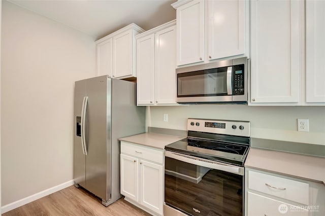 8605 E Gilman Ave, Arlington, WA 98223 - kitchen with stainless steel appliances, light wood-style floors, white cabinetry, and light countertops