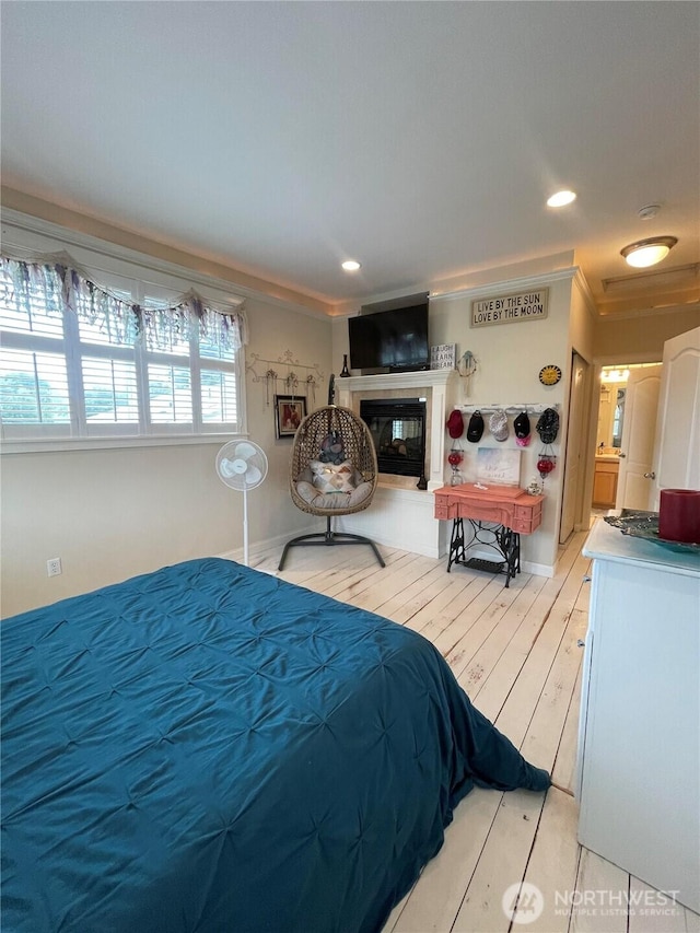 208 Taurus Blvd SW, Ocean Shores, WA 98569 - bedroom with ornamental molding, a tiled fireplace, and light wood-style floors