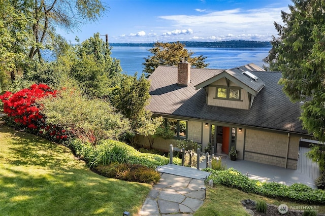 14830 Glen Acres Rd SW, Vashon, WA 98070 - view of front of property featuring a water view, a chimney, a front lawn, and a shingled roof