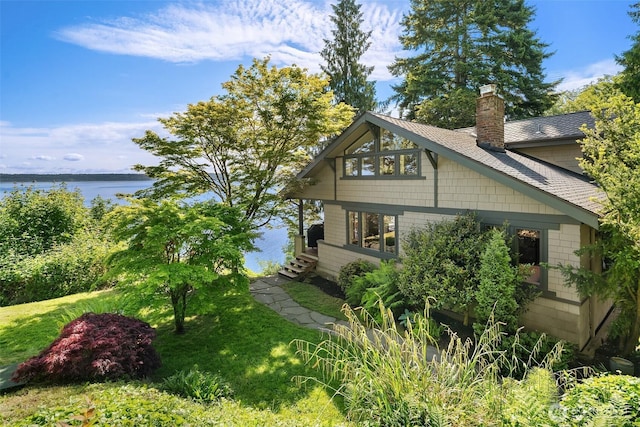 14830 Glen Acres Rd SW, Vashon, WA 98070 - view of side of property featuring a chimney, a lawn, a water view, and a shingled roof