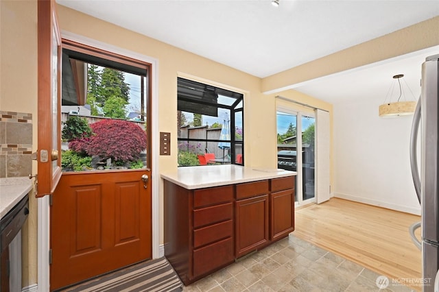 4245 Williams Ave W, Seattle, WA 98199 - kitchen with freestanding refrigerator, light countertops, dishwasher, pendant lighting, and baseboards