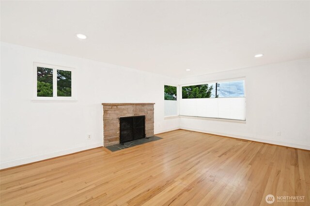 4245 Williams Ave W, Seattle, WA 98199 - unfurnished living room featuring wood finished floors, baseboards, recessed lighting, and a stone fireplace