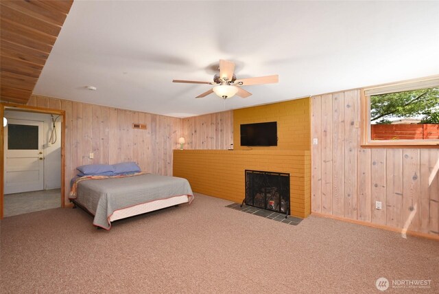 4245 Williams Ave W, Seattle, WA 98199 - carpeted bedroom featuring wood walls, a brick fireplace, and ceiling fan
