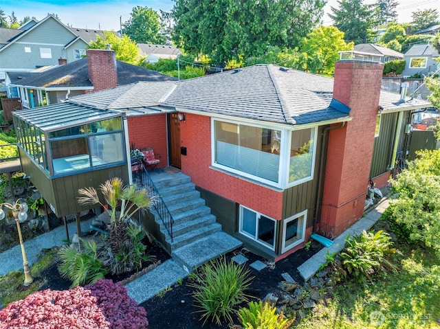 4245 Williams Ave W, Seattle, WA 98199 - view of front of home featuring a chimney, brick siding, a shingled roof, and a residential view