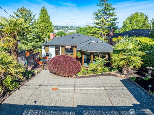 4245 Williams Ave W, Seattle, WA 98199 - view of front of house with a chimney, a patio area, and roof with shingles