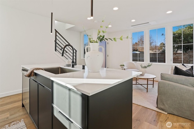 8757B Palatine Ave N, Seattle, WA 98103 - kitchen featuring open floor plan, a kitchen island with sink, light countertops, light wood-style flooring, and recessed lighting