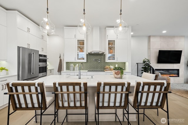 18809 99th Pl NE Unit A, Bothell, WA 98011 - kitchen featuring wall chimney exhaust hood, a sink, stainless steel appliances, decorative backsplash, and white cabinetry