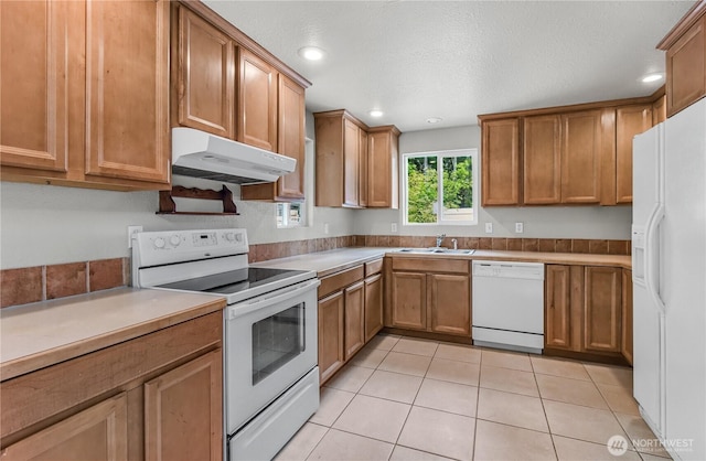 15828 3rd Ave SE, Bothell, WA 98012 - kitchen with white appliances, under cabinet range hood, a sink, brown cabinets, and recessed lighting
