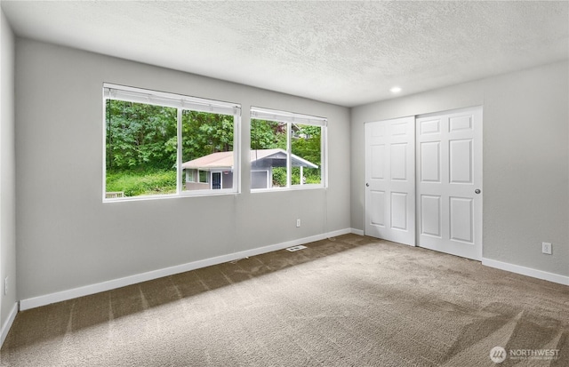 15828 3rd Ave SE, Bothell, WA 98012 - unfurnished bedroom featuring carpet flooring, a textured ceiling, a closet, and baseboards