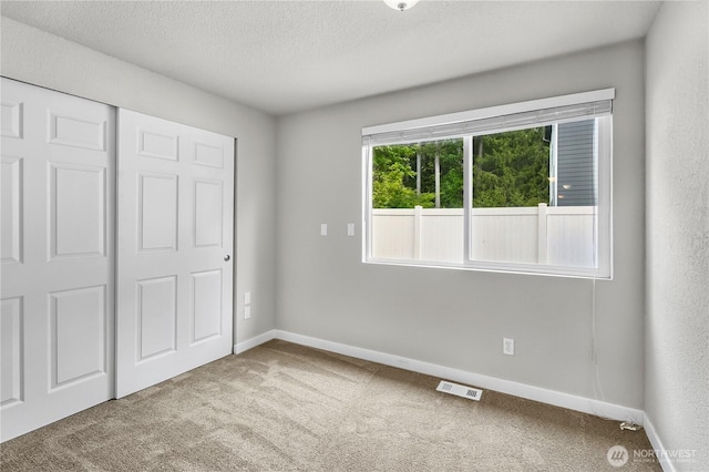 15828 3rd Ave SE, Bothell, WA 98012 - unfurnished bedroom with carpet, a textured ceiling, baseboards, and a closet