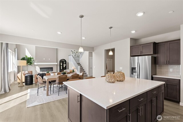 769 SE 12th Pl Unit 29, North Bend, WA 98045 - kitchen featuring stainless steel fridge with ice dispenser, light countertops, dark brown cabinets, light wood finished floors, and recessed lighting