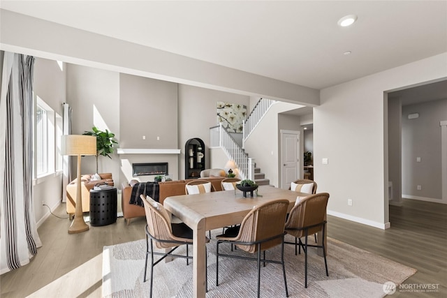 769 SE 12th Pl Unit 29, North Bend, WA 98045 - dining room featuring a glass covered fireplace, stairs, wood finished floors, baseboards, and recessed lighting
