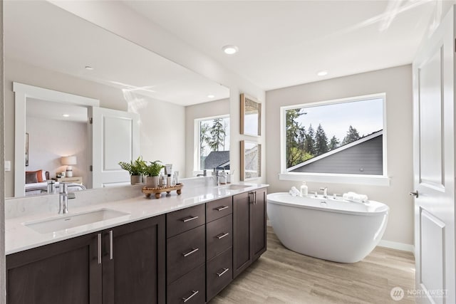 769 SE 12th Pl Unit 29, North Bend, WA 98045 - full bath featuring a freestanding bath, wood finished floors, double vanity, recessed lighting, and baseboards