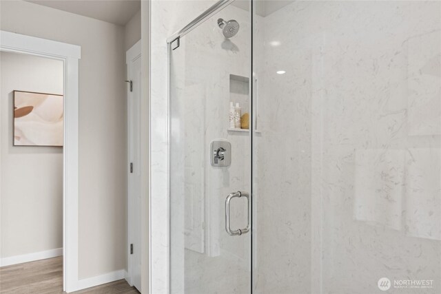 769 SE 12th Pl Unit 29, North Bend, WA 98045 - full bathroom with a marble finish shower, wood finished floors, and baseboards
