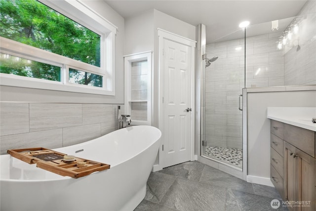 415 Snow Mass Ln, Yakima, WA 98908 - full bathroom featuring a stall shower, a soaking tub, vanity, and tile walls