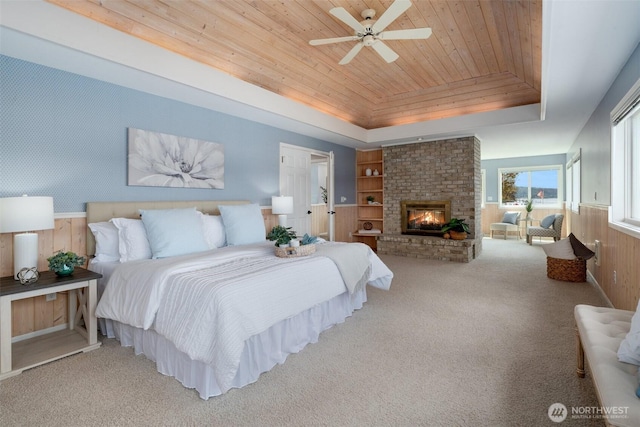 11521 E State Route 106, Union, WA 98592 - carpeted bedroom with a tray ceiling, wood ceiling, a fireplace, wooden walls, and wainscoting