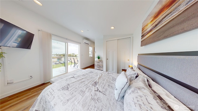 890 Magellan Ave NE Unit 2, Ocean Shores, WA 98569 - bedroom with a wall mounted AC, access to exterior, wood finished floors, a closet, and baseboards