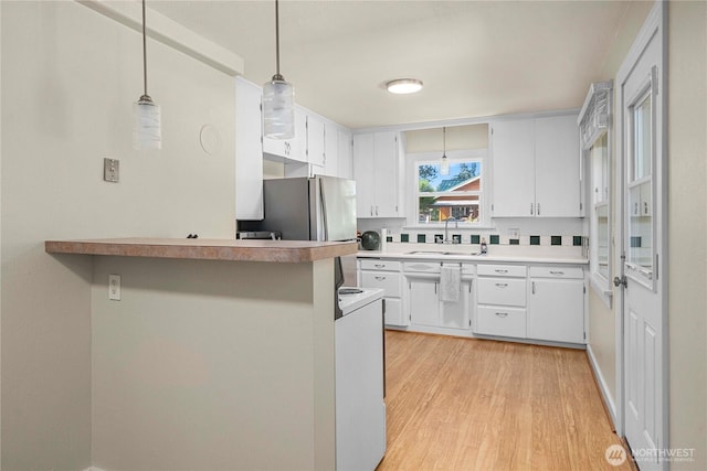 4211 108th Ave E, Edgewood, WA 98372 - kitchen with freestanding refrigerator, light wood-style floors, white cabinets, and decorative light fixtures