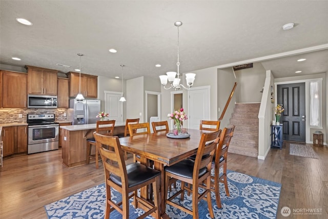 301 K St NE, Quincy, WA 98848 - dining space featuring recessed lighting, wood finished floors, a chandelier, stairway, and baseboards