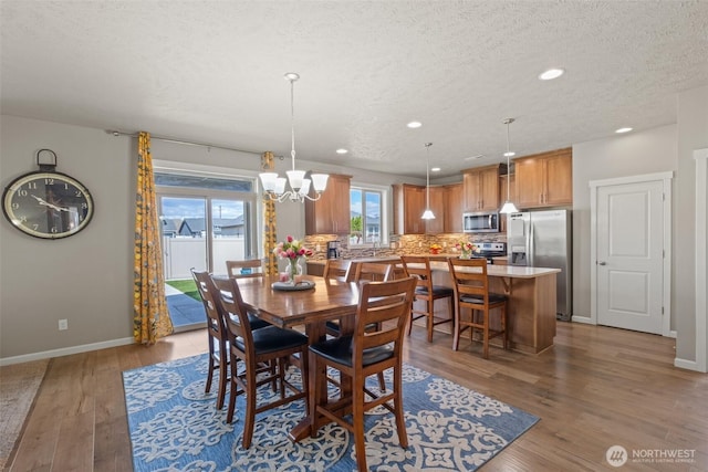 301 K St NE, Quincy, WA 98848 - dining space with a chandelier, a textured ceiling, recessed lighting, wood finished floors, and baseboards