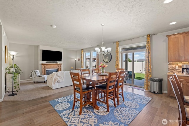 301 K St NE, Quincy, WA 98848 - dining area with a textured ceiling, a glass covered fireplace, a chandelier, light wood-type flooring, and recessed lighting