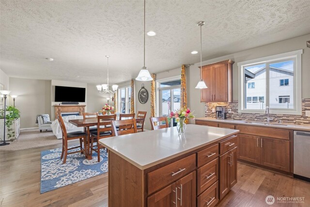301 K St NE, Quincy, WA 98848 - kitchen with a sink, a textured ceiling, stainless steel dishwasher, wood finished floors, and healthy amount of natural light