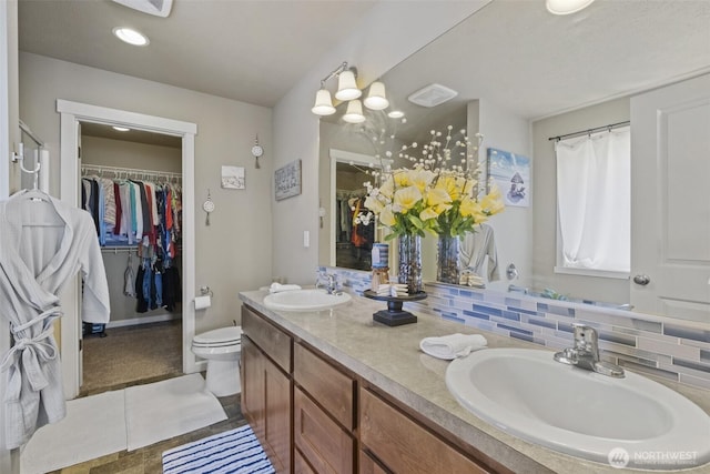 301 K St NE, Quincy, WA 98848 - full bathroom featuring double vanity, a spacious closet, toilet, backsplash, and recessed lighting