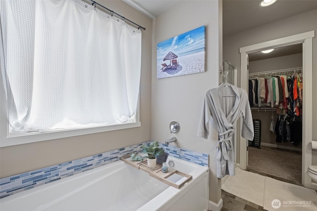 301 K St NE, Quincy, WA 98848 - bathroom with a bath, a walk in closet, tile patterned flooring, and toilet