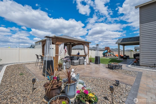 301 K St NE, Quincy, WA 98848 - fenced backyard with an outdoor living space with a fire pit, a gazebo, a patio area, and a playground