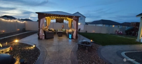 301 K St NE, Quincy, WA 98848 - patio terrace at dusk with a gazebo, a fire pit, and a patio area