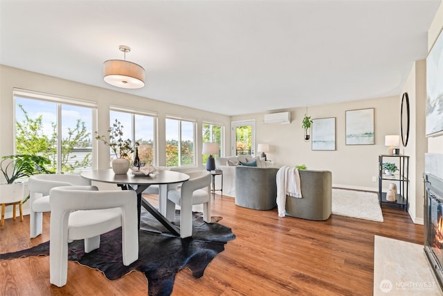 1965 12th Ave W Unit 202, Seattle, WA 98119 - dining space featuring an AC wall unit, wood finished floors, and baseboards