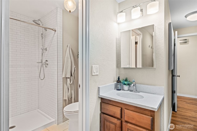 1965 12th Ave W Unit 202, Seattle, WA 98119 - bathroom with vanity, tiled shower, toilet, and a textured wall