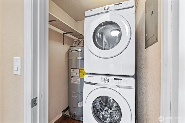 1965 12th Ave W Unit 202, Seattle, WA 98119 - washroom featuring stacked washer and clothes dryer, strapped water heater, wood finished floors, and baseboards
