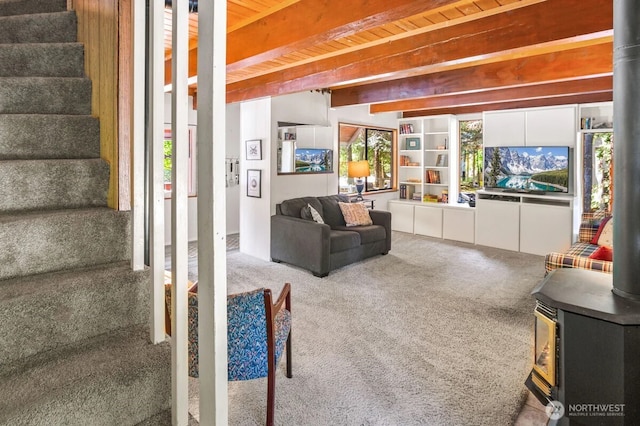 11318 583rd Ave E, Enumclaw, WA 98022 - carpeted living room featuring a wood stove, stairs, and wooden ceiling with exposed beams