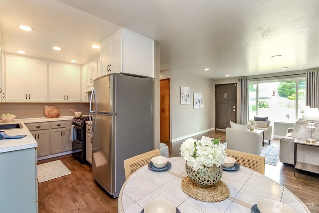 13812 Golden Given Rd E, Tacoma, WA 98445 - kitchen featuring range with gas stovetop, freestanding refrigerator, dark wood-style floors, open floor plan, and light countertops