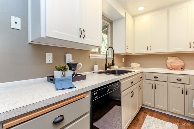 13812 Golden Given Rd E, Tacoma, WA 98445 - kitchen with black dishwasher, a sink, light countertops, wood finished floors, and white cabinets