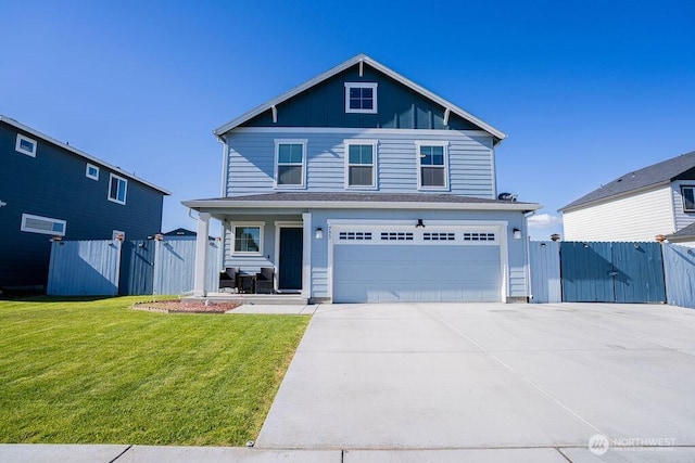 733 K St NE, Quincy, WA 98848 - view of front of home with an attached garage, driveway, covered porch, board and batten siding, and a gate