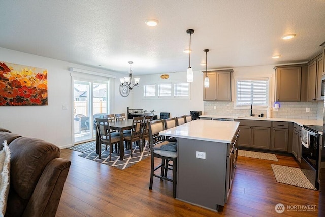 733 K St NE, Quincy, WA 98848 - kitchen featuring a sink, a chandelier, black / electric stove, a center island, and healthy amount of natural light