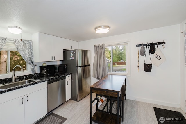 2395 SE Salmonberry Rd, Port Orchard, WA 98366 - kitchen with appliances with stainless steel finishes, a sink, dark countertops, and light wood finished floors