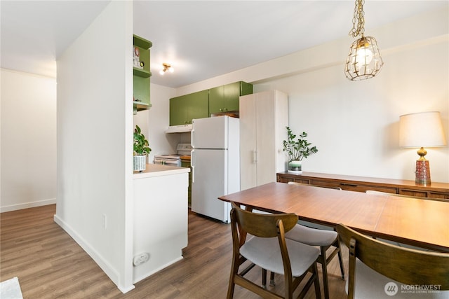 1200 Boylston Ave Unit 505, Seattle, WA 98101 - kitchen with white appliances, green cabinets, under cabinet range hood, wood finished floors, and baseboards