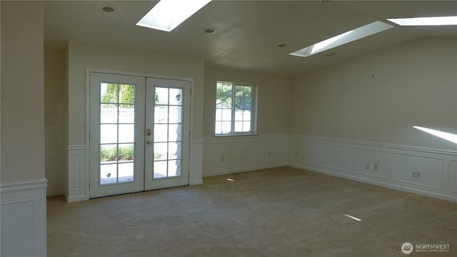 4635 N Defiance St, Tacoma, WA 98407 - empty room featuring a skylight, light colored carpet, a decorative wall, french doors, and wainscoting