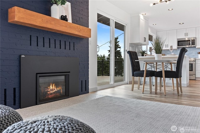 1345 Rainbow Ln, Camano Island, WA 98282 - dining area featuring light wood-style floors, recessed lighting, and a fireplace