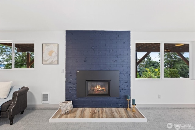 1345 Rainbow Ln, Camano Island, WA 98282 - living area with carpet, baseboards, a fireplace, and healthy amount of natural light